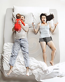 Top view of happy family with one newborn child in bedroom.