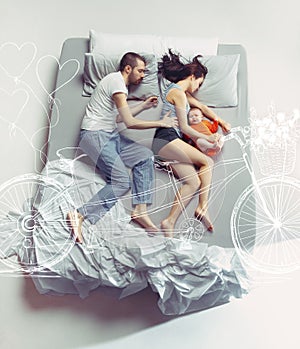 Top view of happy family with one newborn child in bedroom and their dreams .