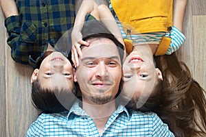 Top view happy father lying on floor with children