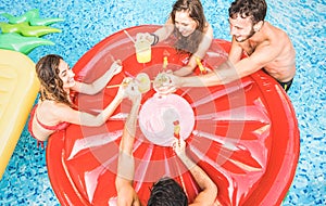 Top view of happy friends drinking cocktails at swimming pool party - Vacation concept with happy guys and girls having fun photo