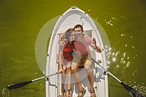 Top view of happy loving couple rowing a small boat on a lake. A fun date in nature. Couple hugging in a boat.