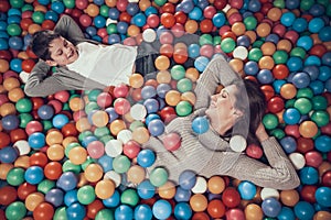 Top view. Happy mom and son in pool with balls