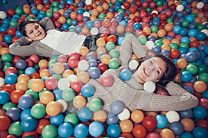 Top view. Happy mom and son in pool with balls