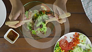 Top view of Health conscious young chief woman tossing a tasty organic green salad