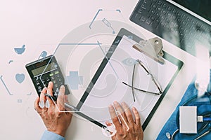 top view of Healthcare costs and fees concept.Hand of smart doctor used a calculator for medical costs in modern hospital with