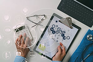 top view of Healthcare costs and fees concept.Hand of smart doctor used a calculator for medical costs in modern hospital with