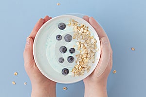 Top view healthy blue spirulina smoothie bowl with blueberry and muesli.