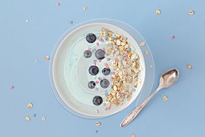 Top view healthy blue spirulina smoothie bowl with blueberry and muesli.