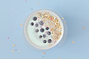 Top view healthy blue spirulina smoothie bowl with blueberry and muesli.
