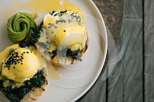 Top view of Healthy Breakfast with Bread Toast and Poached Egg with spinach, avocado on wooden table. Healthy food and