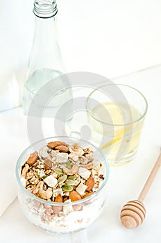 Top view healthy breakfast of homemade granola cereal with milk, strawberry, nuts and fruit, honey with drizzlier on