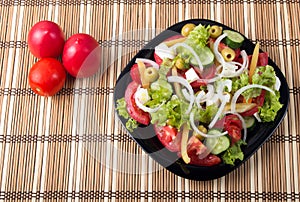 Top view on a healthy and natural vegetable salad with tomato, c
