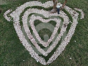 Top view  of heart shape white stones on the grass for landscape design. Backdrop for Valentineâ€™s day