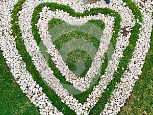 Top view  of heart shape white stones on the grass for landscape design. Backdrop for Valentineâ€™s day