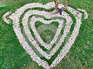 Top view of heart shape white stones on the grass for landscape design. Backdrop for Valentineâ€™s day or romantic background