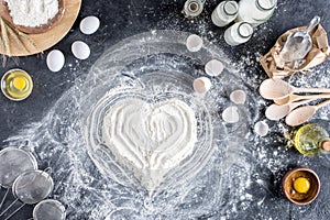 Top view of heart sign made of flour and various ingredients for baking