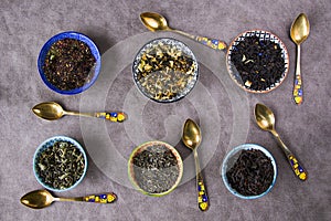 Top view of the herbal and natural dry tea variation in bowls with  vintage spoons