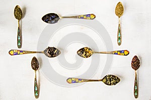 Top view of the herbal and natural dry tea variation vintage spoons on white background