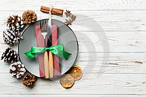 Top view of holiday dinner decorated with dried fruit and cinnamon on wooden background. Set of plate, urensil and New Year