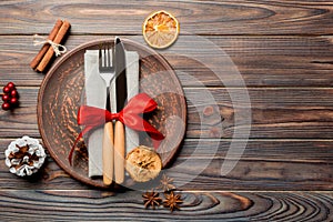 Top view of holiday dinner decorated with dried fruit and cinnamon on wooden background. Set of plate, urensil and New Year