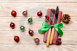 Top view of holiday set of fork and knife on wooden background. Close up of Christmas decorations and toys. New Year Eve concept