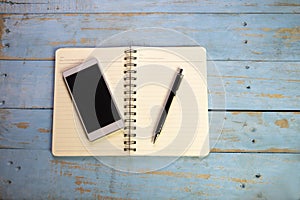 Top View of Home Office Desk. Calendar, Diary book, Meeting Agenda, Smartphone and pencil place on wooden table, Working space at