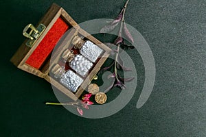 Top view of homeopathy medicine bottles in wooden old box with wild flower and herb on dark background