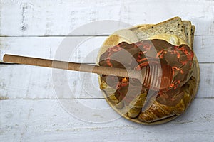 Top view of honey dripping from a honey dipper on fresh bread on wooden table