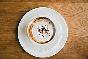 Top view of hot cappuccino coffee cup on wood table at cafe,food and drink.