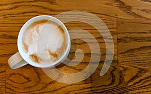 Top view of hot cappuccino coffee cup on wooden table in coffee cafe. copy space for adding text