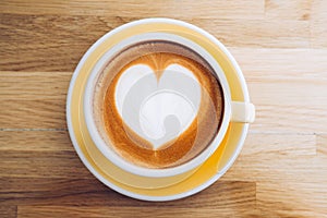 Top view of hot cappuccino coffee cup on wooden tray with heart latte art on wood table at cafe,Banner size food and drink concept