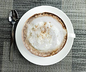 Top view of hot coffee cappuccino cup with spiral milk foam