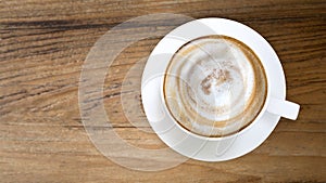 Top view of hot coffee cappuccino on wood table background.