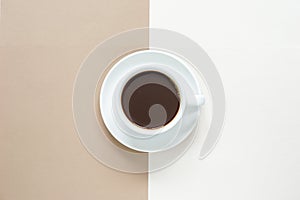 top view of hot coffee cup in white ceramic mug placed on white ceramic coffee coasters put in the centre during brown  and white