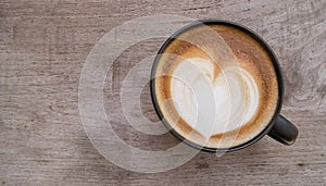 Top view of hot coffee latte art heart shape foam on wood background