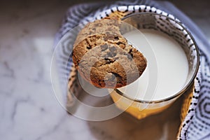 Top view of hot milk in a glass and a chocolate chip cookie