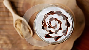 Top view of hot mocha coffee latte art chocolate heart shape spiral glass on table background, vintage style