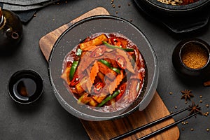 Top view of Hot and spicy Stir-fried rice cake ( Tteokbokki ) put in the black bowl or dish and placed on a