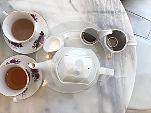 Top view of hot tea with milk and jar,tea break time on marble table