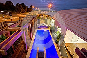 A top view of house waterpool in night with street behind the ho