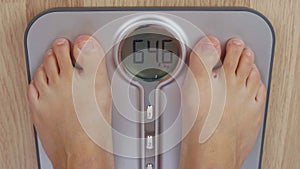 Top view human foot stepping on weighting scale for measuring body mass