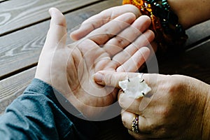 Top view of human hand and psychic or fortune teller explains lines on palm. Palmistry