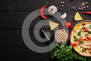 Top view of hummus ingredients. Yellow hummus and chips on a wooden background. Hummus preparation concept. Copy space.