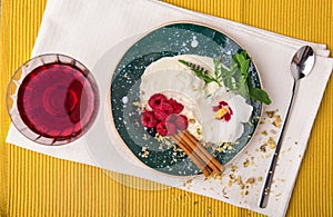 A top view of an ice cream. Fantastic dessert with berries and mint. Grape juice and ice cream on a yellow background.