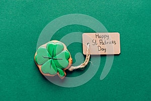 top view of icing cookie in shape of shamrock on green, st patricks day concept