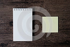 Top view image of blank notebook and empty sticky note paper on
