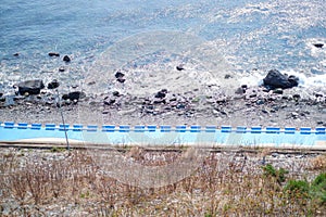 Top view image of blue mural wall and street with people walking by with sea view in Huinnyeoul Culture Village, Busan, South