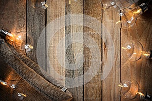 Top view image with bulblight garland and canvas bag on raw rustic background. photo