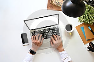 Top view image of businessman`s hand typing on white blank screen computer laptop.