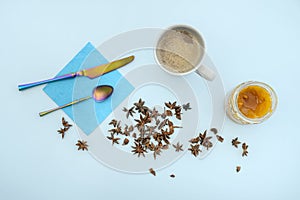 Top view image of cafe con leche, a jar of bitter orange jam, dried aniseed photo